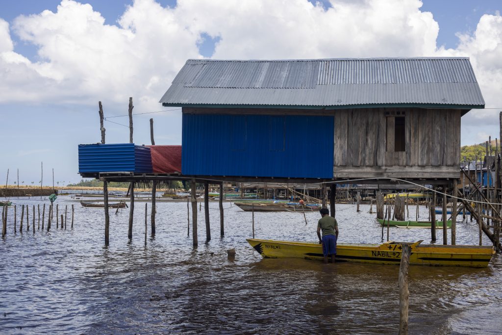 Nelayan Suku Bajau tengah menyiapkan kapalnya di dekat rumah.